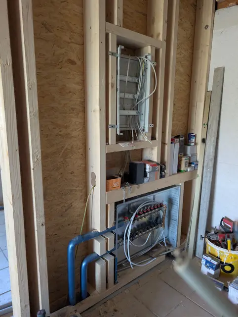 Vorwandinstallation im Holzbau mit Unterverteiler, Heizungsrohren und Leitungen
