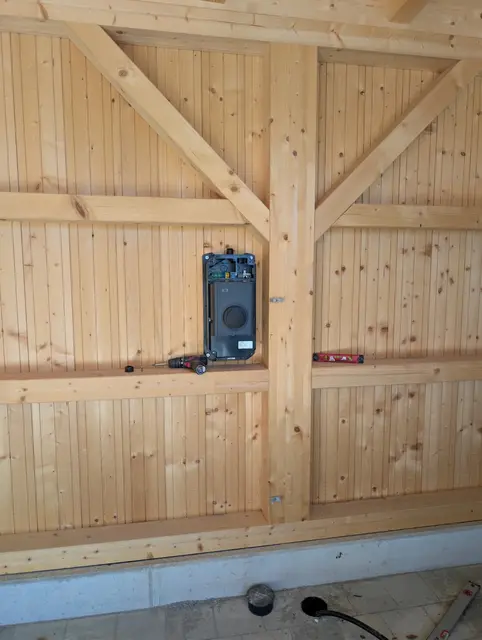 Anschlussdose mit Messgerät an einer Holzverschalung im Giebel