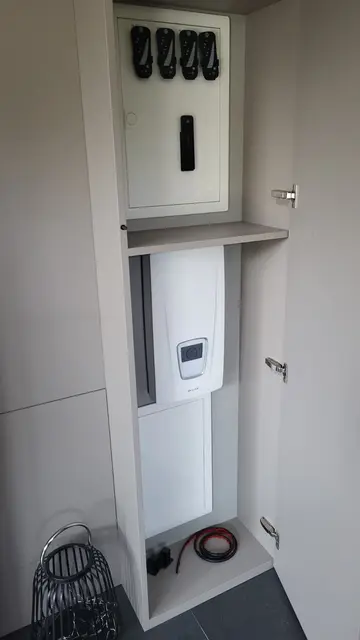 Hausanschlusskasten mit NH-Sicherungen über dem Anschlussgerät in einer schmalen Technik-Nische