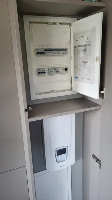 Geöffnete Technik-Nische mit Anschlusskasten und darunterliegendem Gerät